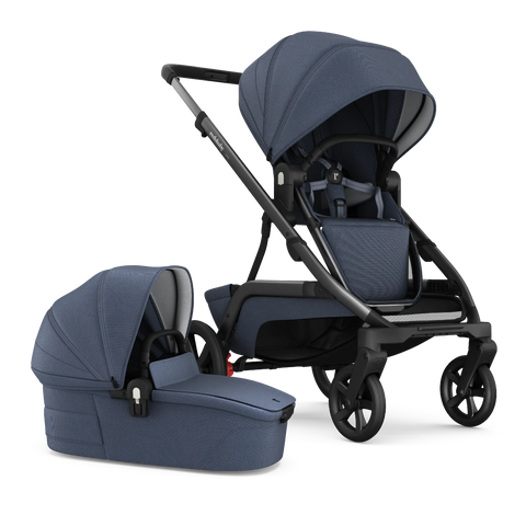 A side-by-side image of the Redsbaby NUVO stroller in blue slate color, featuring both the pram and bassinet attachments. The pram on the left has a sleek, ergonomic design with a curved handle and a reclining seat with a secure five-point harness system, while the bassinet on the right showcases a protective hood and a flat sleeping surface, both made with textured, high-quality fabric. The stroller demonstrates its versatility with easy-to-attach modules for different stages of a baby's development.