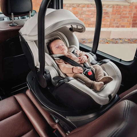 Newborn peacefully sleeping in the Britax Römer Baby-Safe Pro Lux Infant Car Seat in Taupe, securely fastened with a 3-point harness, demonstrating comfort and safety in a car.